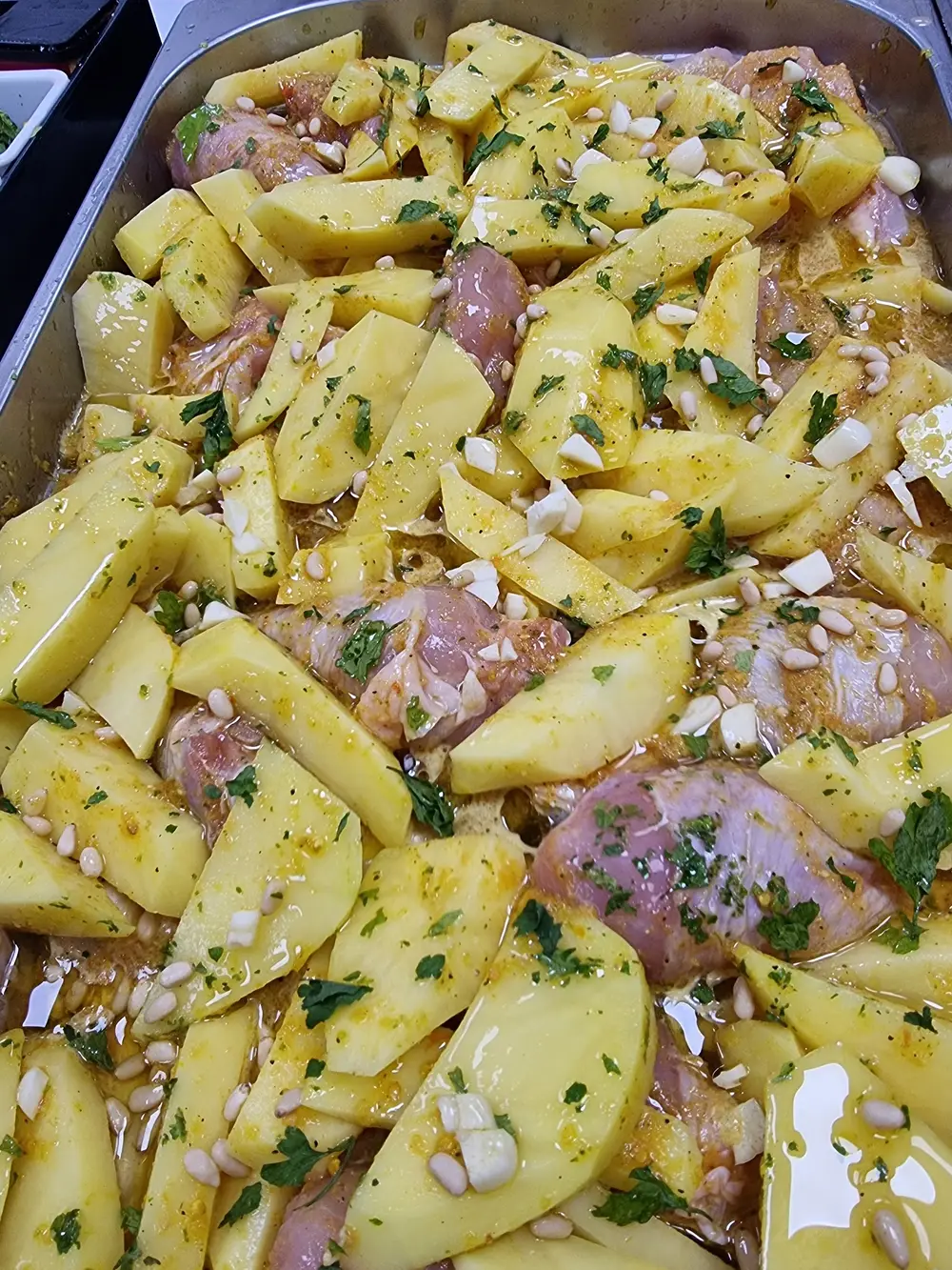 Pollo al ajillo con patatas y piñones